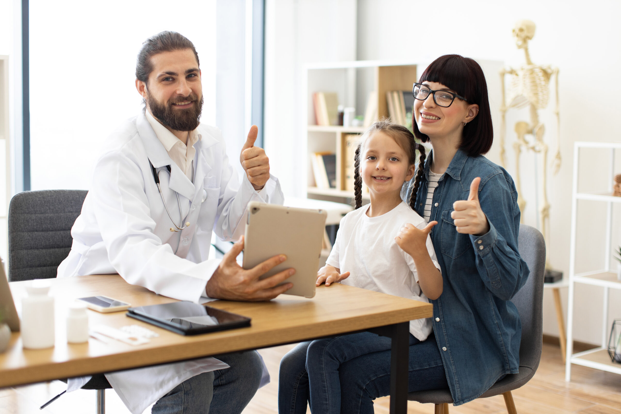 Caucasian doctor shares positive test results with young girl and mother